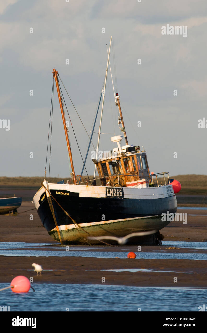 Barca da pesca sui suoi ormeggi a Brancaster Stathe Foto Stock
