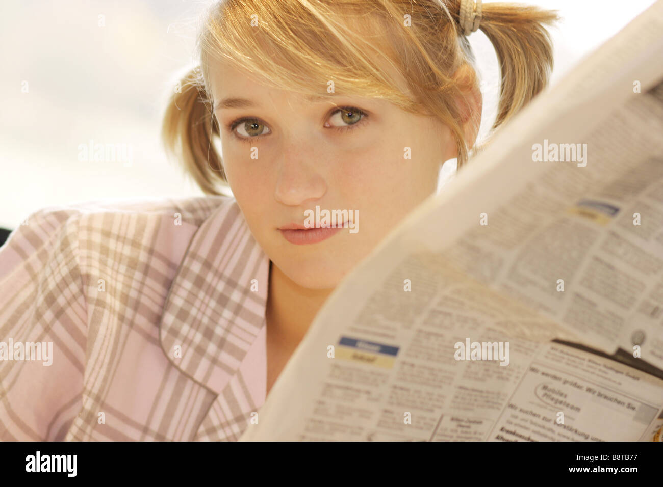 Giovane donna con il giornale la mattina, Germania Foto Stock