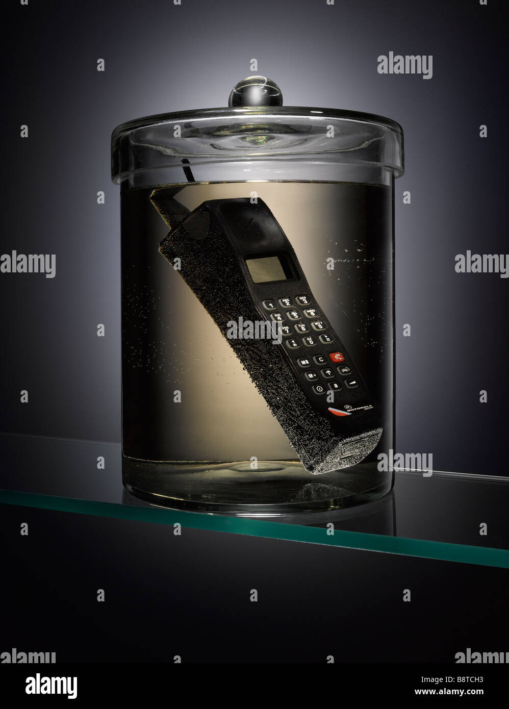 Un vecchio telefono in un vaso di campione Foto Stock