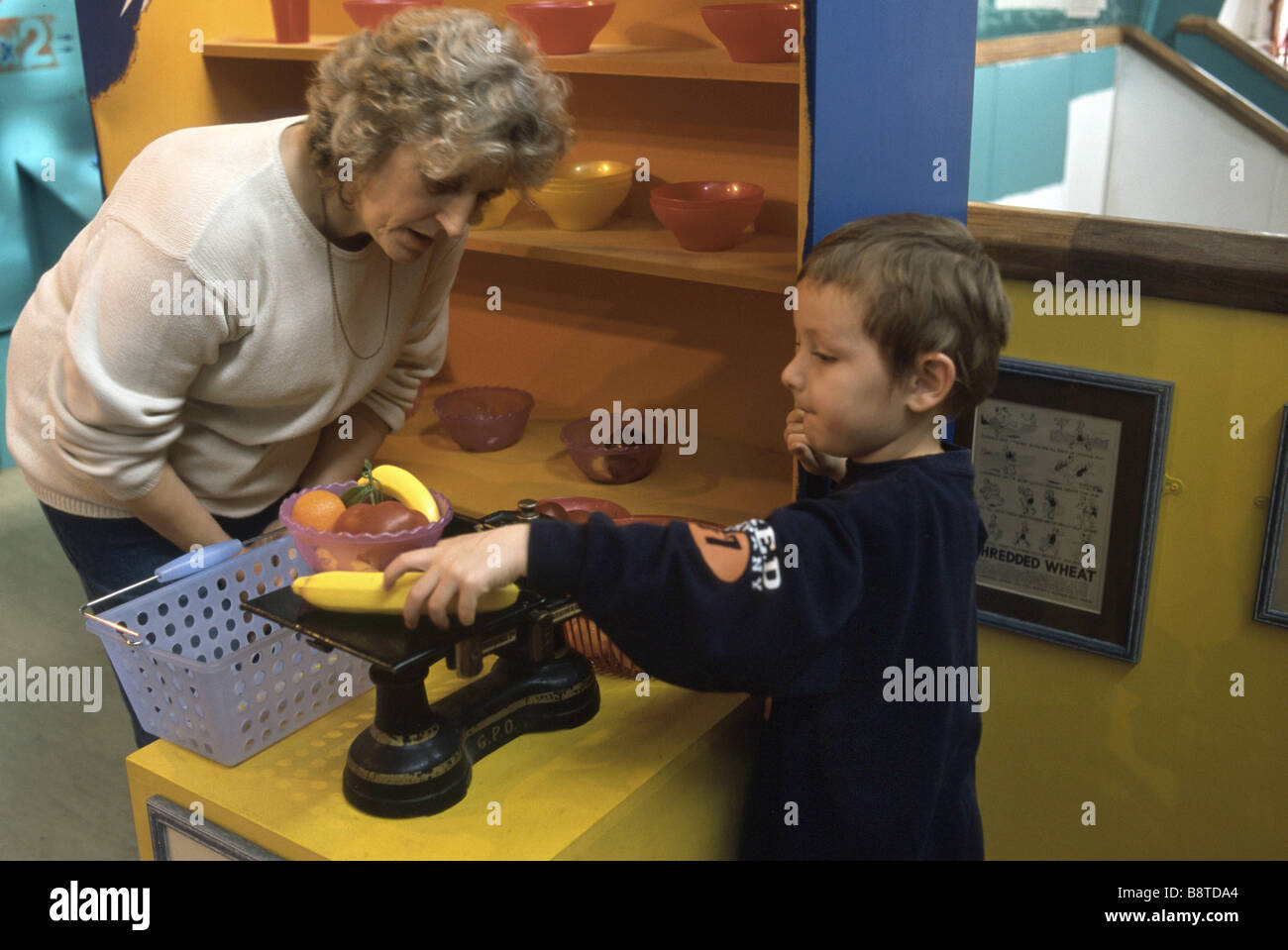 La scuola materna di ragazzo giocando in un giocattolo negozio di alimentari Foto Stock