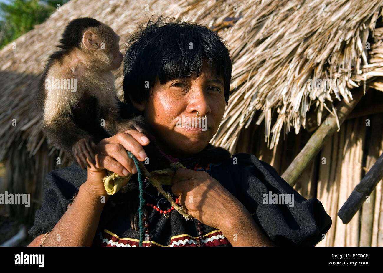 Una donna Kuna gioca con il suo animale domestico cariblanca faccia bianca scimmia cappuccino in un villaggio a Panama la regione di Darien Foto Stock