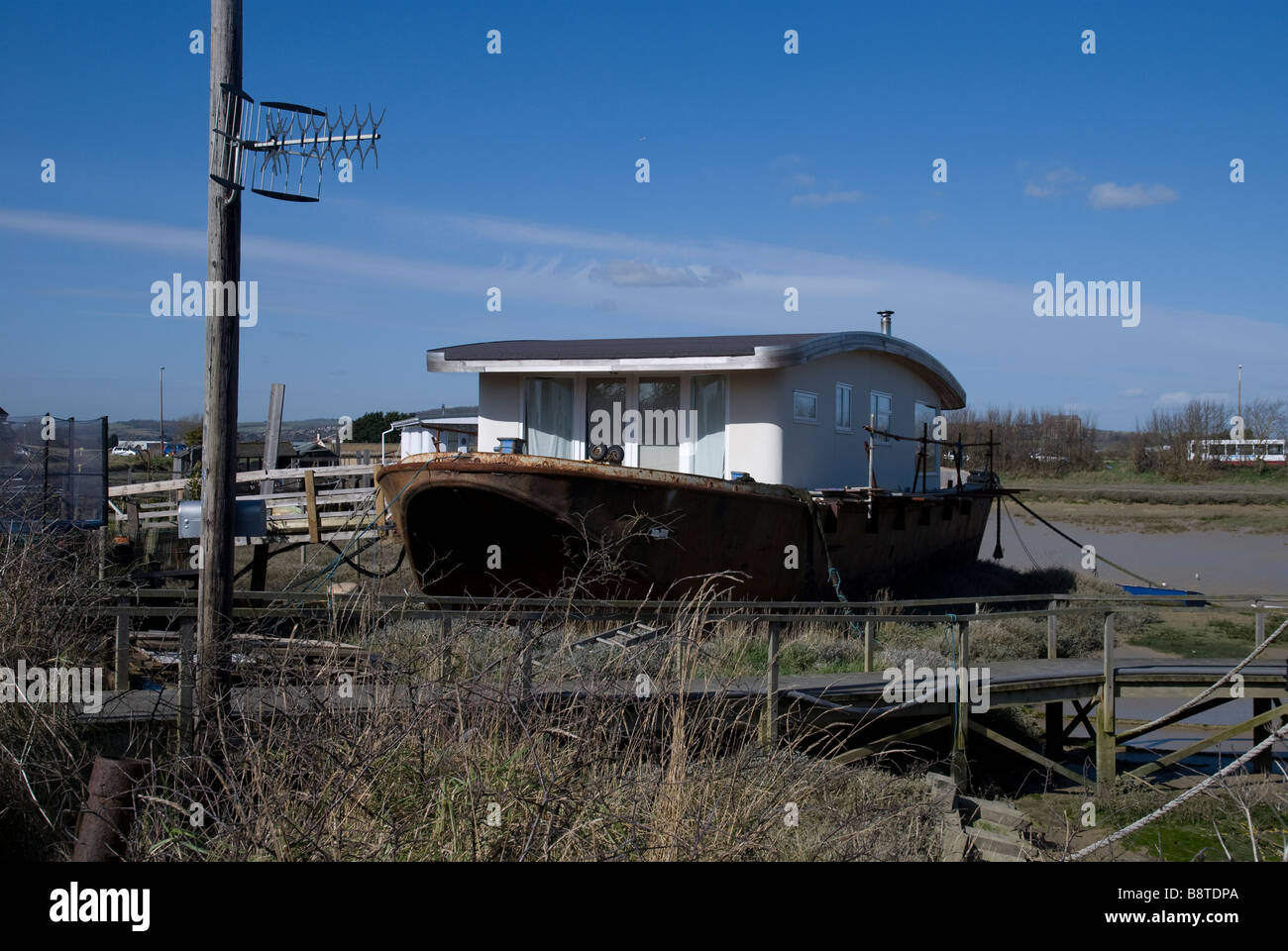 Una grande casa galleggiante su ormeggi a Shoreham Beach, West Sussex, in Inghilterra. Foto Stock