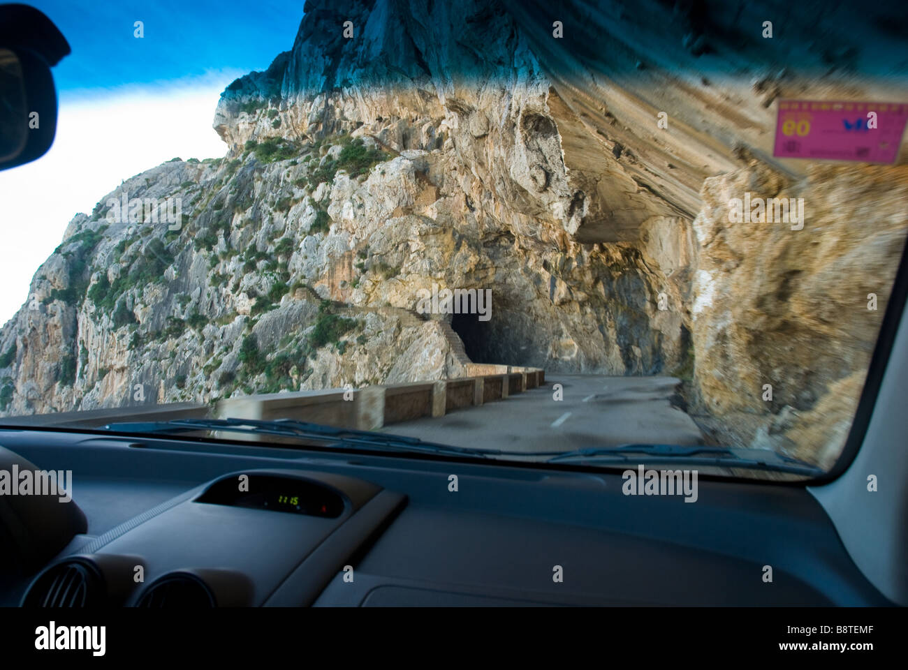 La stretta strada tortuosa sul modo per Cap Formentor su Mallorca, come visto attraverso un parabrezza di veicolo. Foto Stock