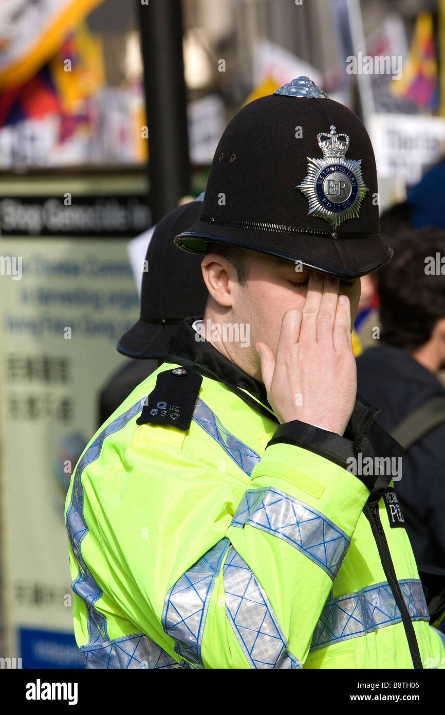 Metropolitan poliziotto fuori dall'ambasciata cinese a Londra come dimostranti protestano contro 50 anni di occupazione cinese in Tibet Foto Stock