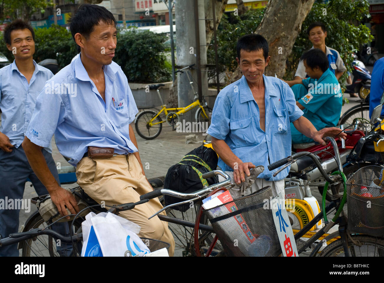 Gli idraulici in attesa per i clienti sulla loro biciclette nella città di Wuhan, provincia di Hubei in Cina. Foto Stock