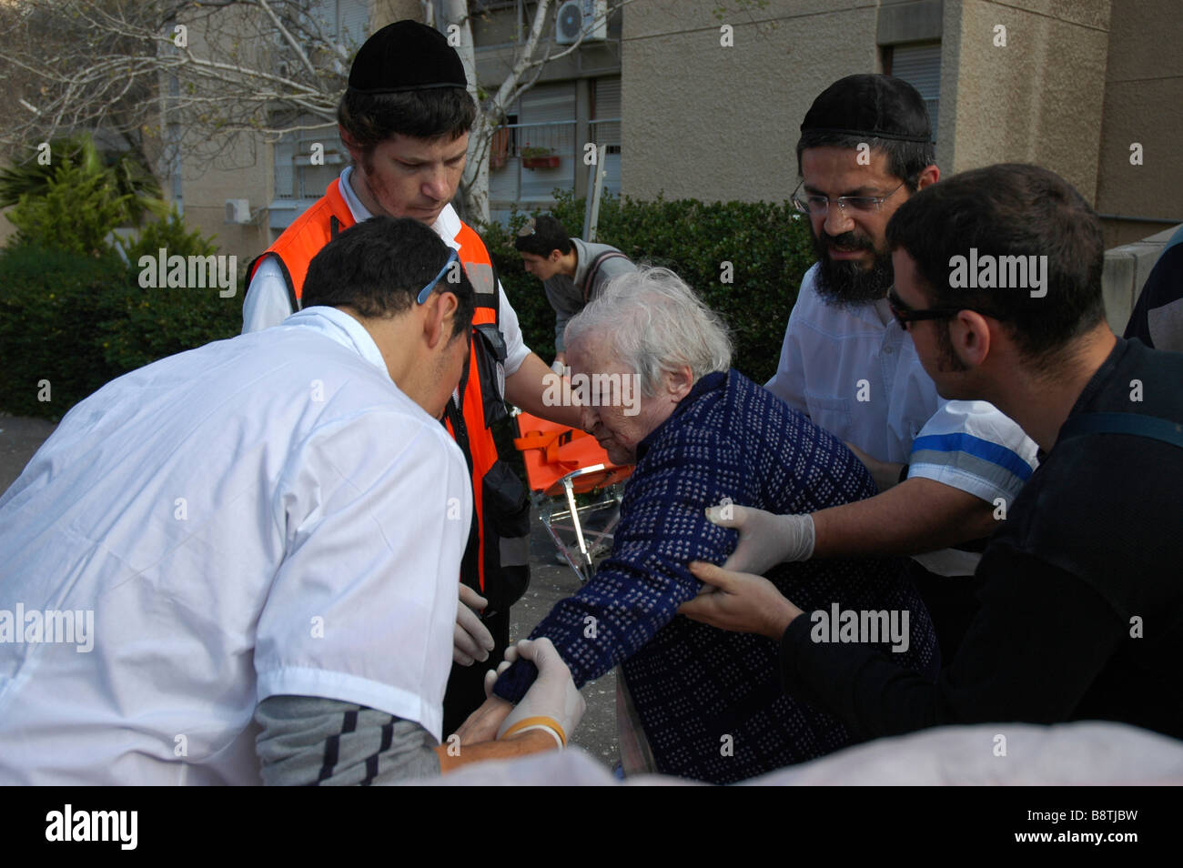 Israele Haifa un appartamento edificio colpito da un missile 30 marzo 2006 il team di risposta alle emergenze di prendersi cura di una vecchia donna Foto Stock