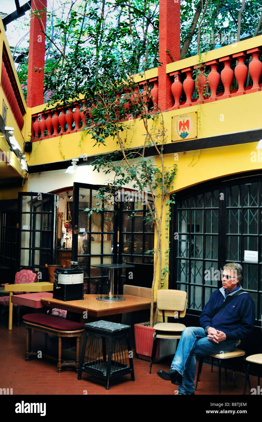Nizza Francia, Scene di strada, all'interno di 'botteghe di antiquariato", nel "Villaggio Segurane', Merchant seduta al di fuori del negozio Foto Stock