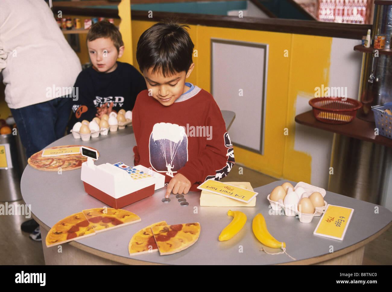 Due la scuola materna di ragazzi giocare in un giocattolo negozio di alimentari Foto Stock