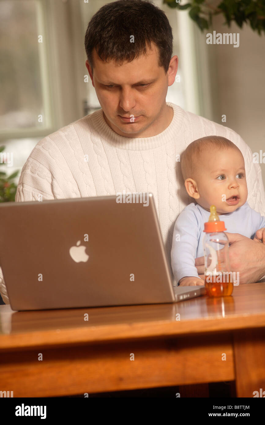 Il figlio e il padre lavorare con il computer portatile Foto Stock