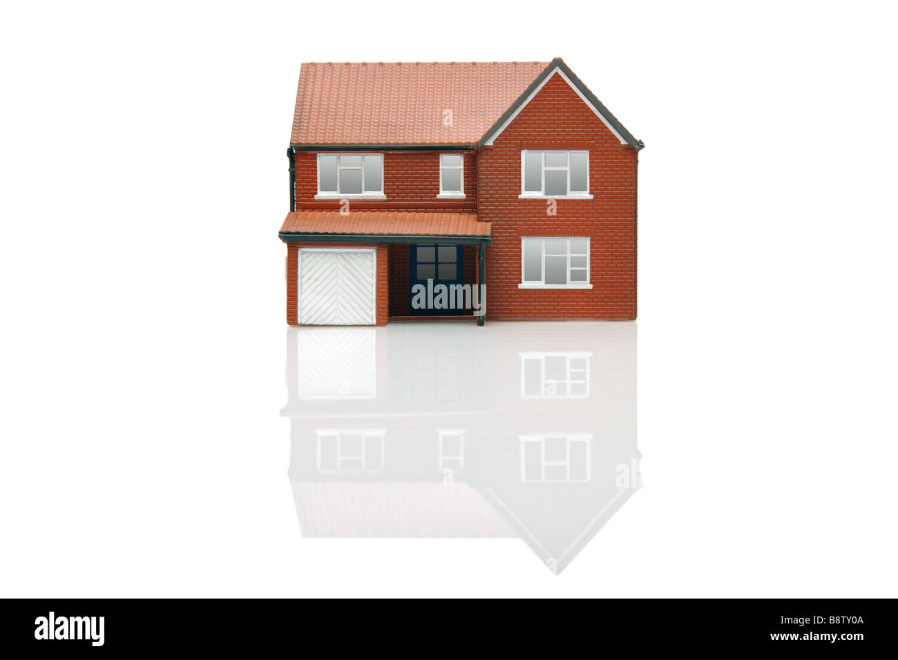 Un modello di casa isolata su uno sfondo bianco con la riflessione Foto Stock