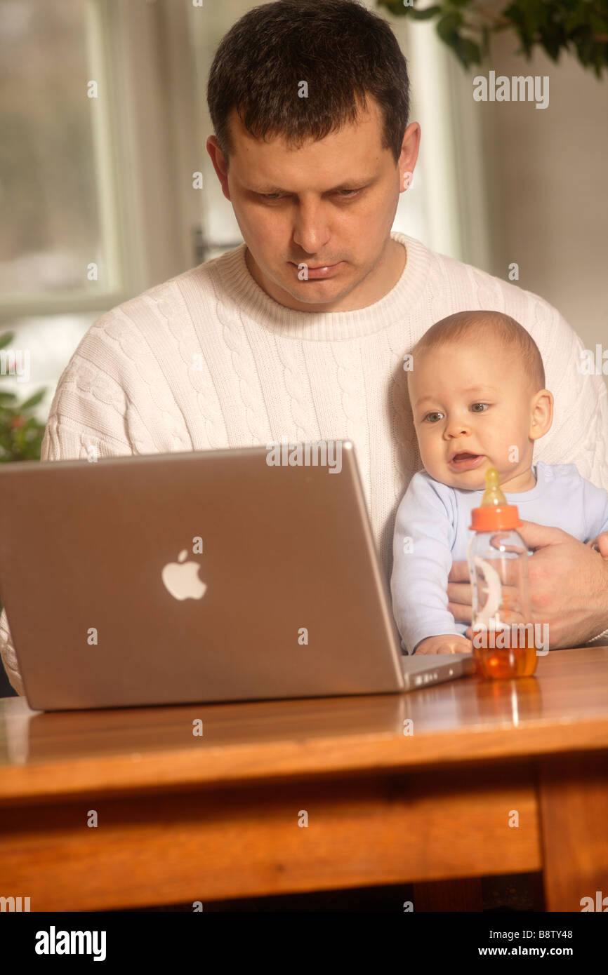 Il figlio e il padre lavorare con il computer portatile Foto Stock