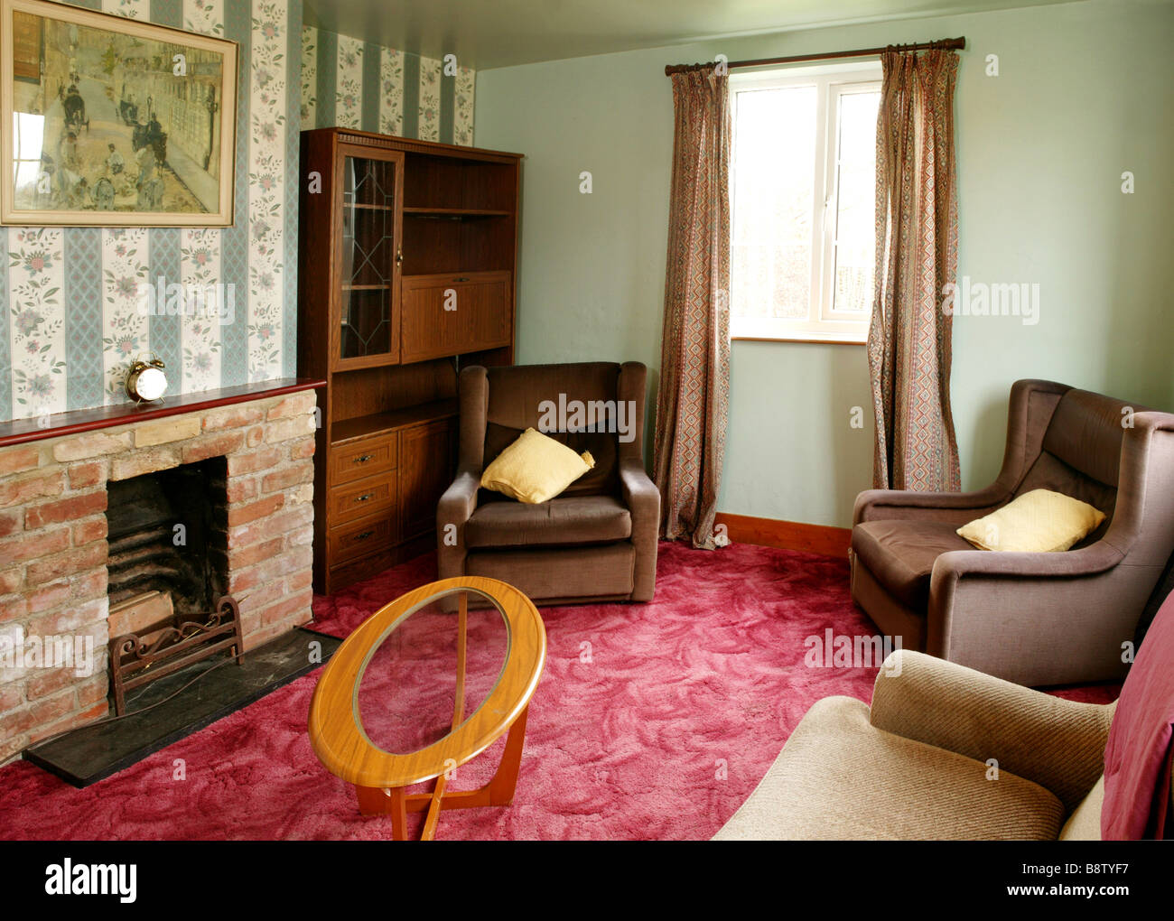 Un 1970 s salotto stile lasciata invariata dal 1970 con pareti verde a rosso shag velluto e arredamento marrone Foto Stock