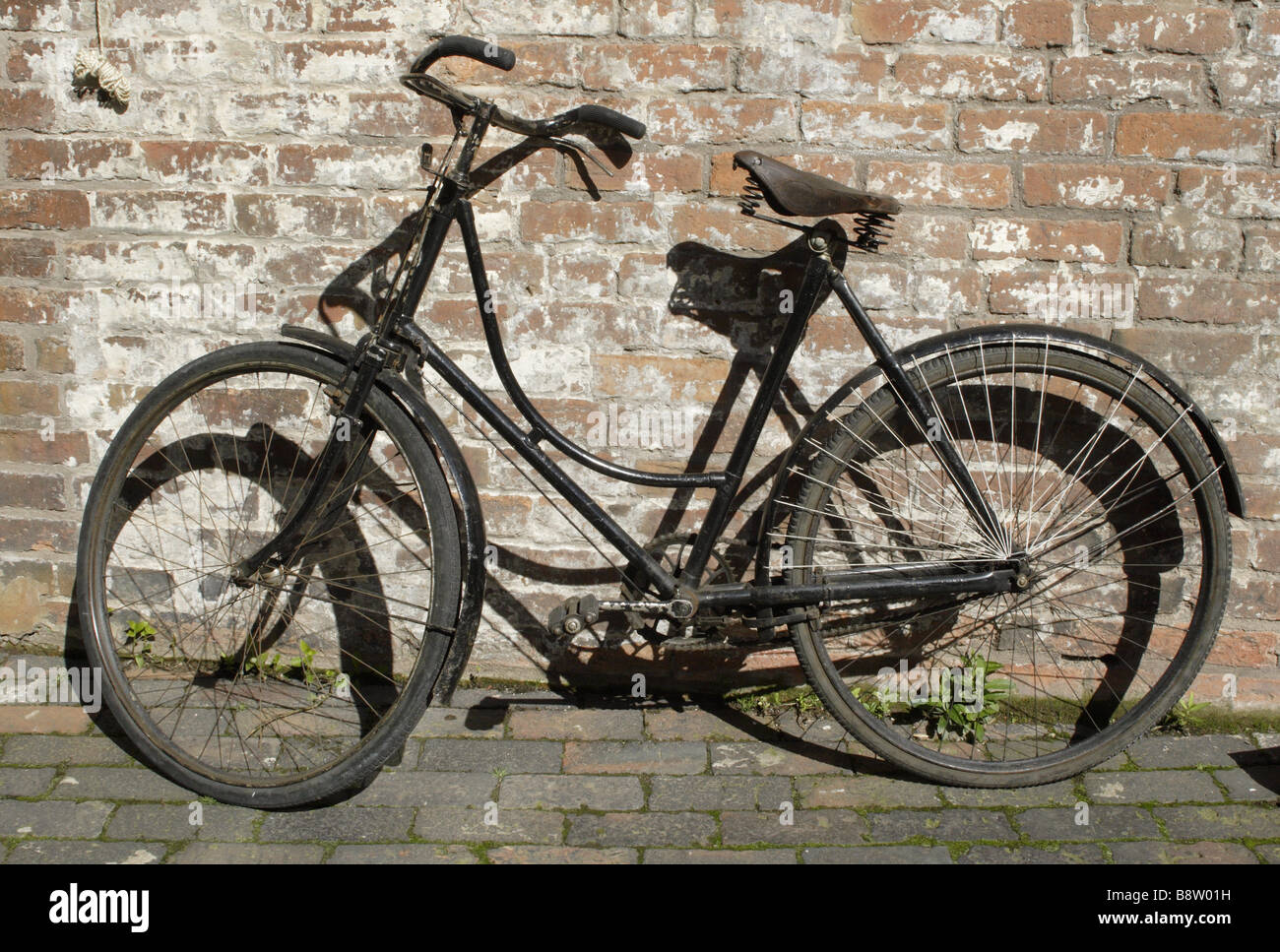 Una bicicletta appoggiata contro il muro del cortile corte 15 Birmingham ritorno alla schiena Foto Stock