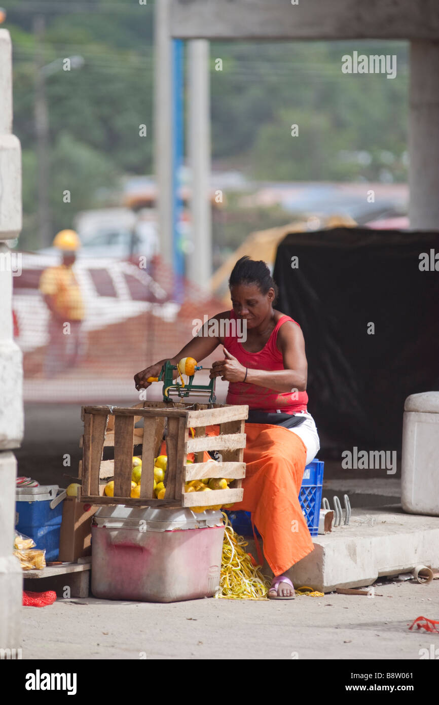 Donna Sbucciare le arance per vendere al semaforo. Città di Panama, Repubblica di Panama, America Centrale Foto Stock