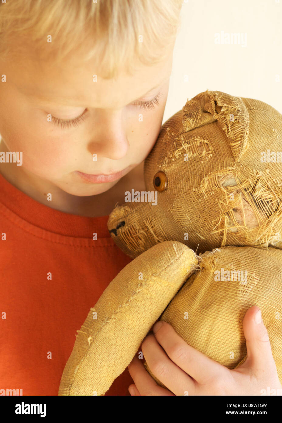 Ragazzo abbraccia il suo orsacchiotto Foto Stock