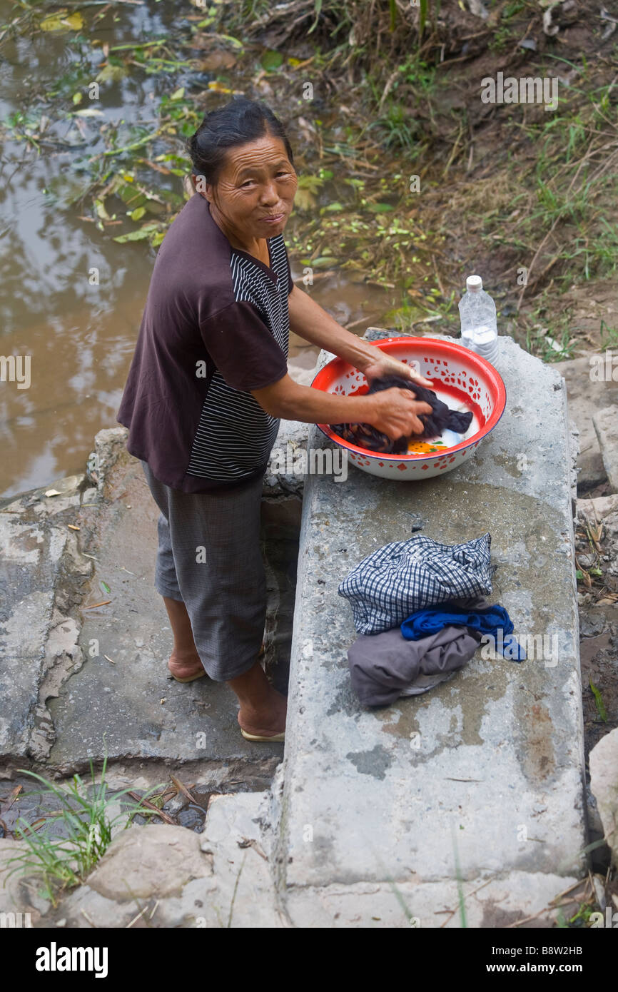 Un agricoltore cinese donna il suo lavaggio biancheria in un fiume in un piccolo villaggio nei pressi di Chongqing, sud-ovest della Cina. Foto Stock