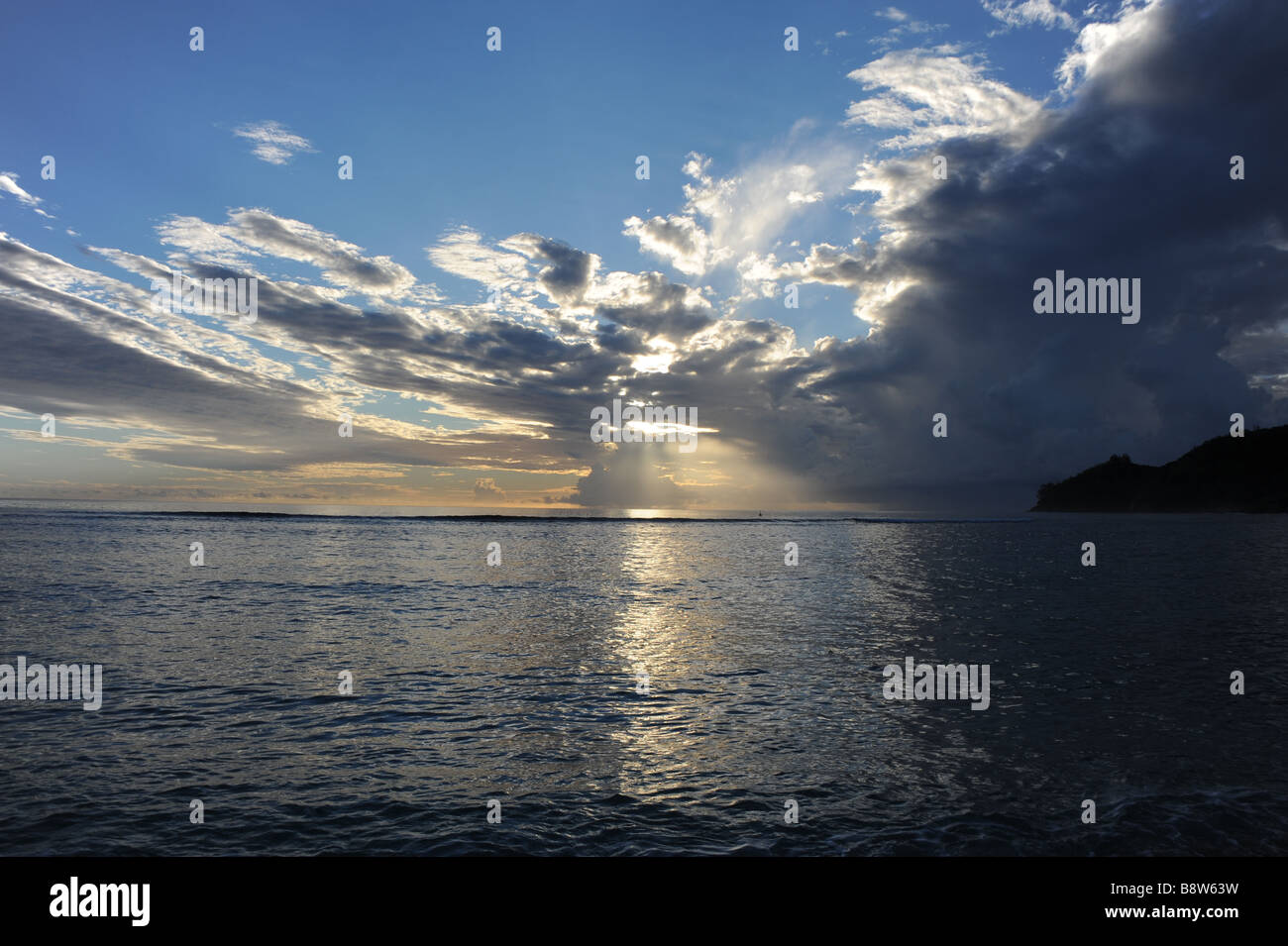 Sunrise in spiaggia - il mare è di riflettere le nuvole e la luce del sole,smal parte del paesaggio sul lato destro Foto Stock