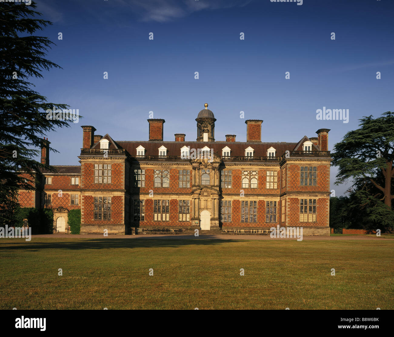 La parte anteriore del nord di Sudbury Hall illuminata dal sole di sera Foto Stock