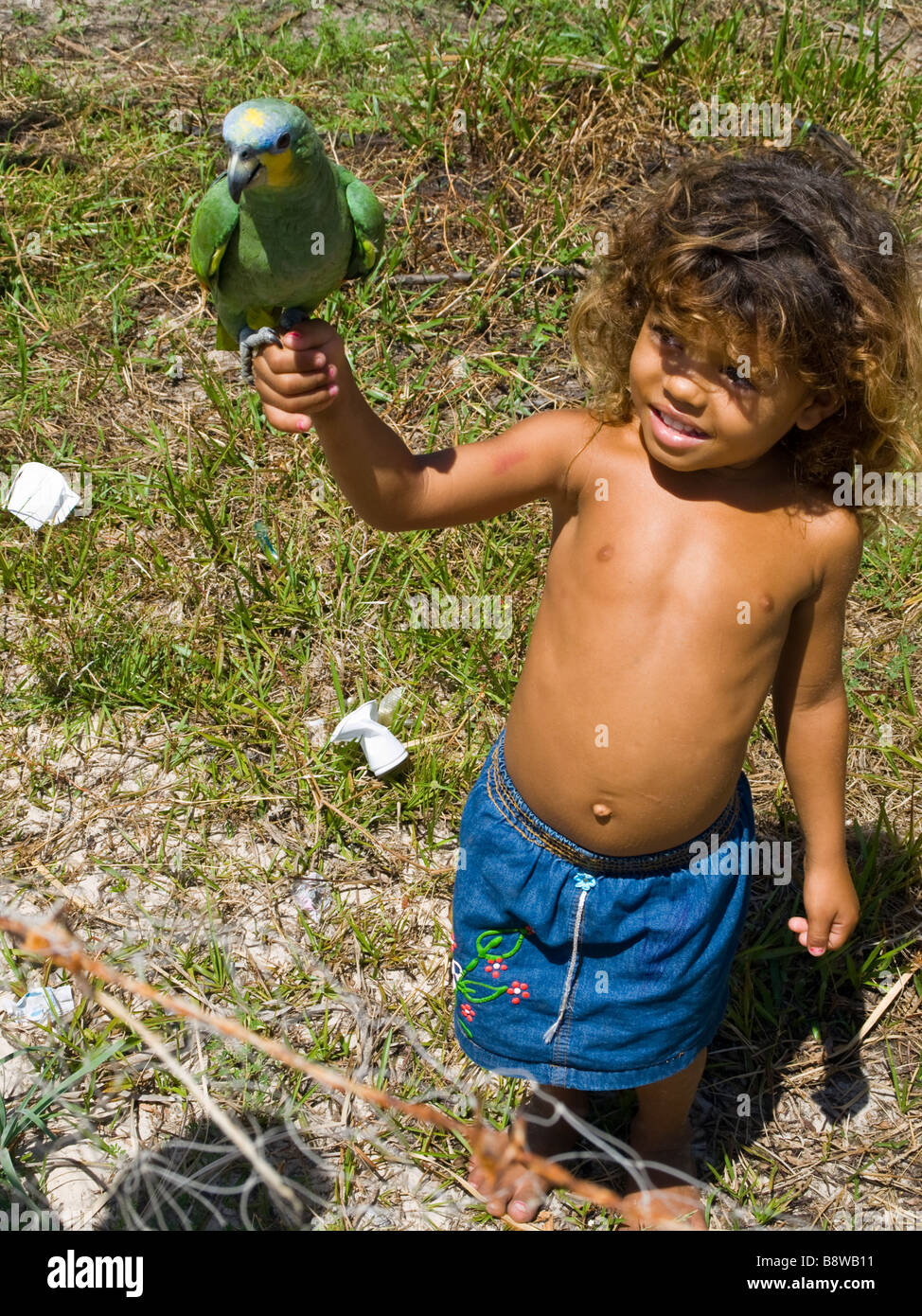 Ragazzo brasiliano con il suo pappagallo in Atins, Lençois Maranhenses, Maranhão, nel nordest del Brasile. Foto Stock