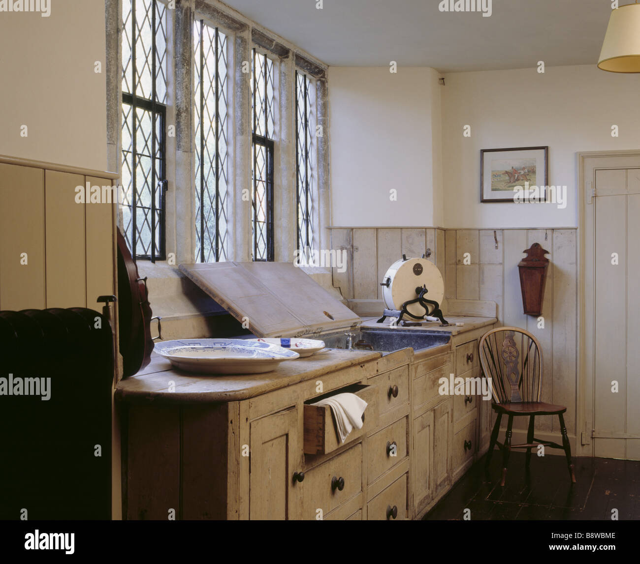 Camera con vista del maggiordomo s dispensa a Ightham Mote che mostra il dissipatore di windows parte del radiatore e la cucina in legno armadi Foto Stock