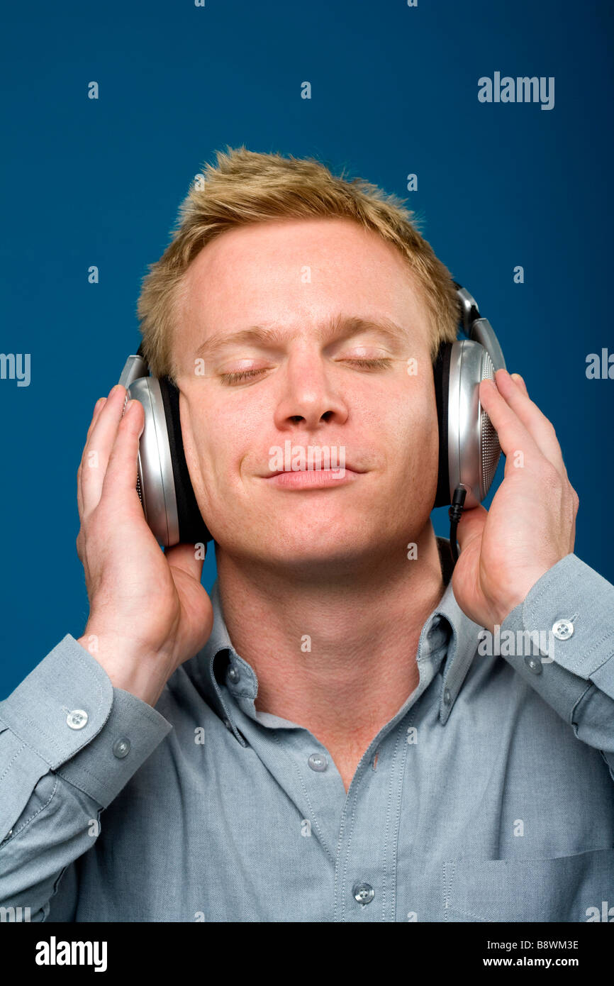 L'uomo l'ascolto di musica con le cuffie Foto stock - Alamy