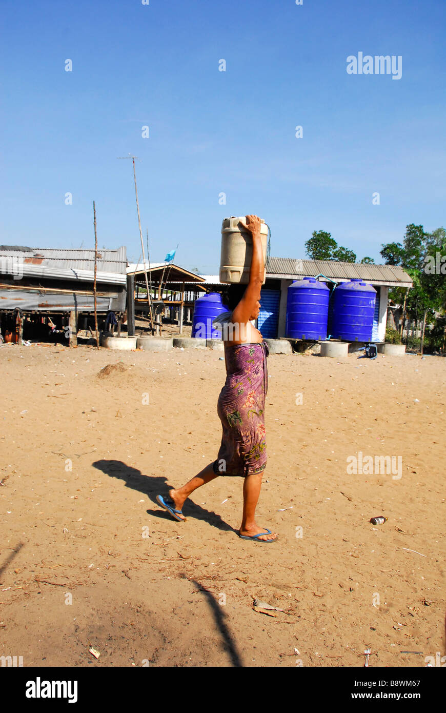 Mare Moken gypsy lady indossando portando acqua benna sulla sua testa, Lhao isola,Ranong,nel sud della Thailandia. Foto Stock