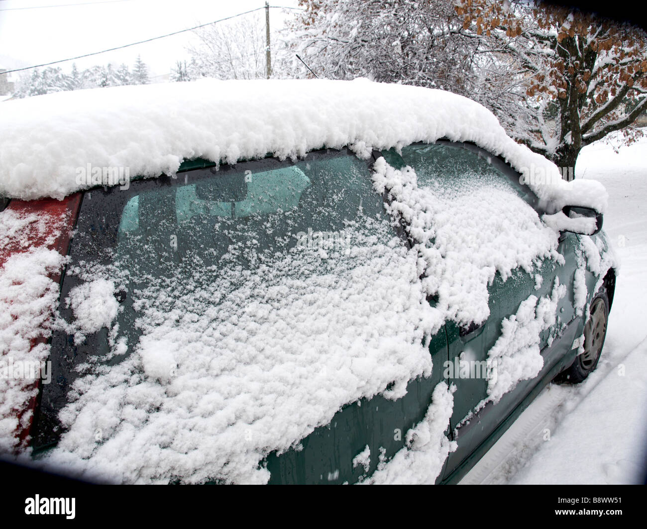 Auto coperto di neve su una strada Foto Stock