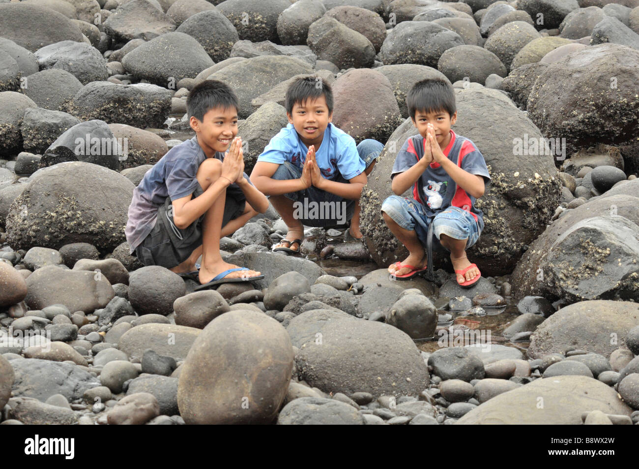 Ragazzi Balinese facendo wai(mettere palme insieme) per saluto anziani,Bali, Indonesia. Foto Stock