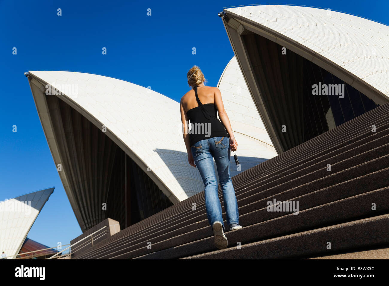 Un turista salite i gradini della Sydney Opera House. Sydney, Nuovo Galles del Sud, Australia Foto Stock