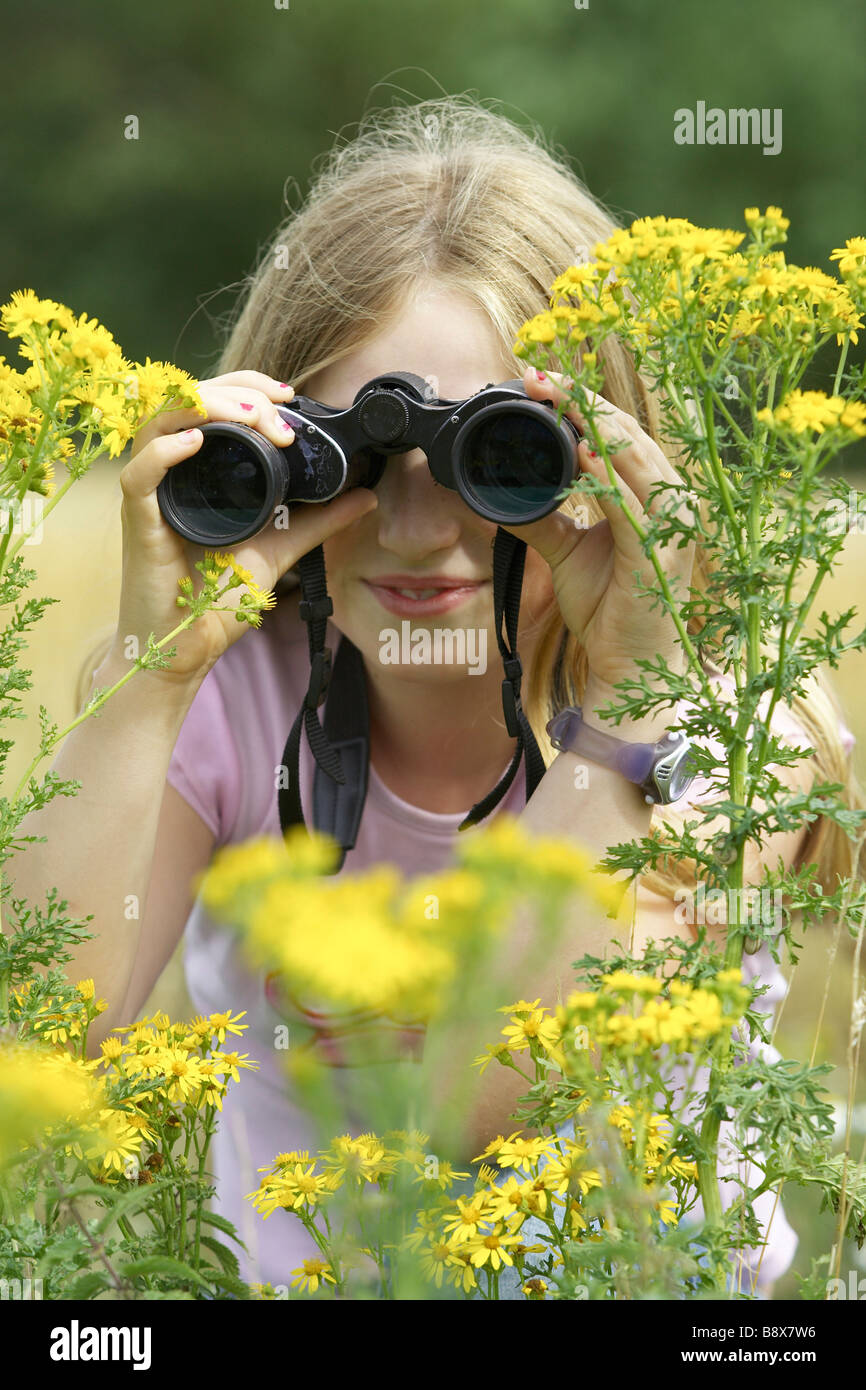 Dieci anni ragazza per il bird watching con il binocolo Foto Stock