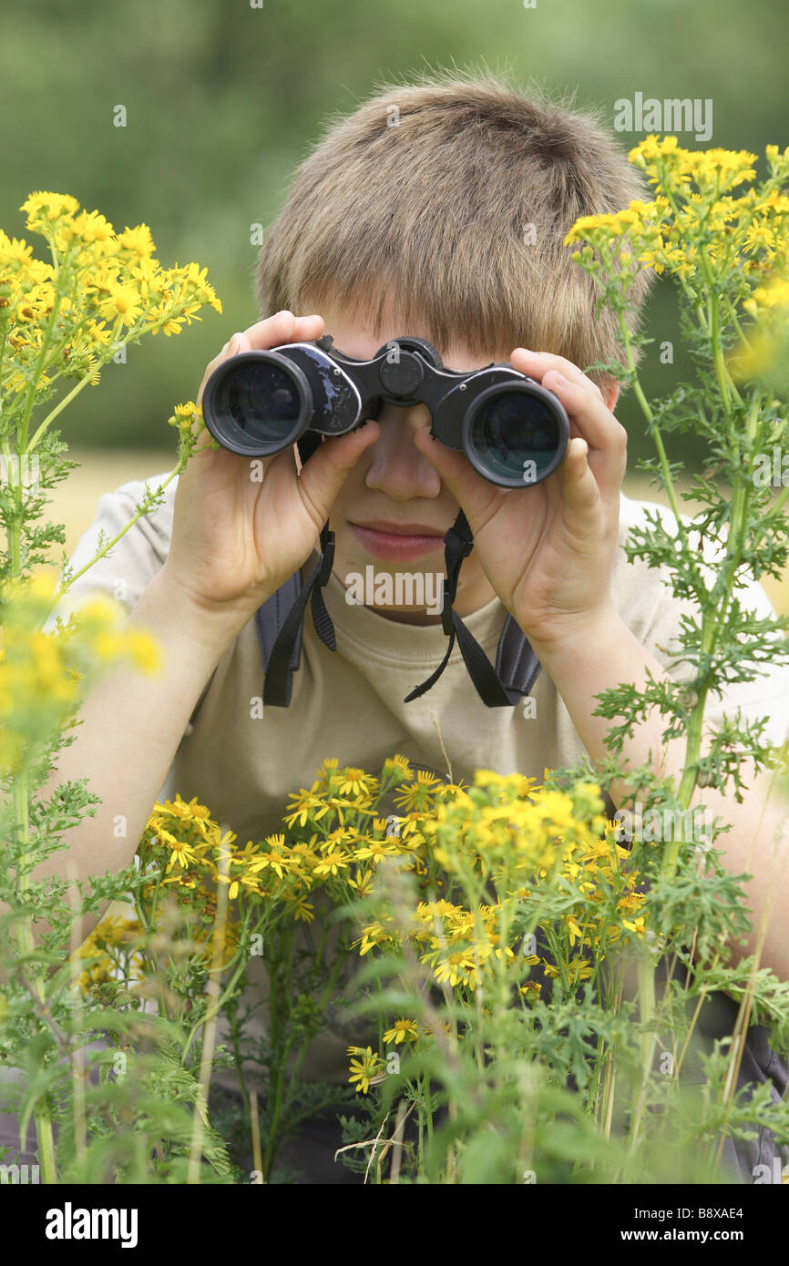 Dieci anni vecchio ragazzo per il bird watching con il binocolo Foto Stock