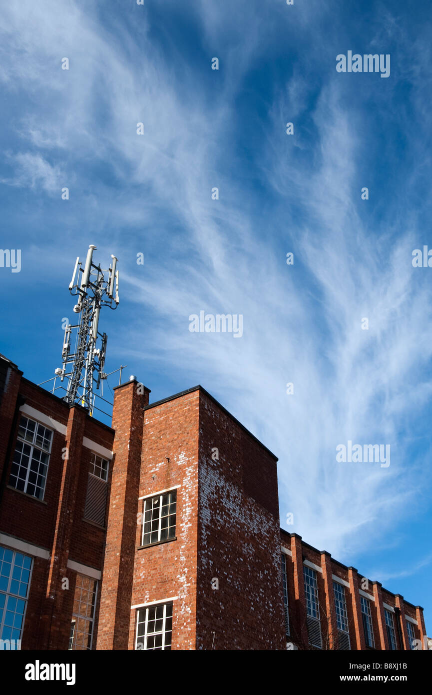 Antenna sulla parte superiore di un edificio di mattoni rossi Foto Stock