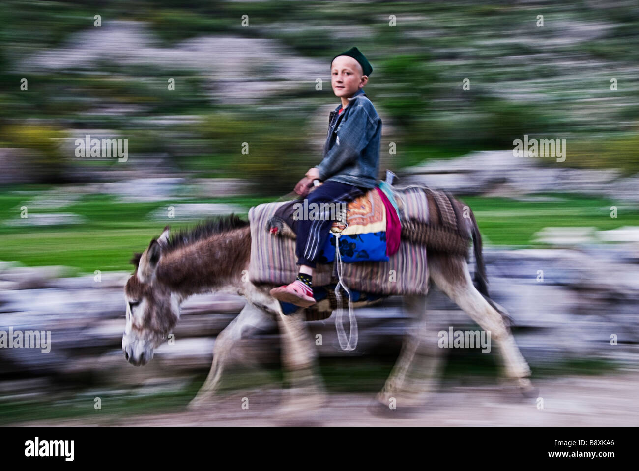 Ragazzo cavalcando un asino vicino a Pendjikent, in Tagikistan, in Asia Foto Stock