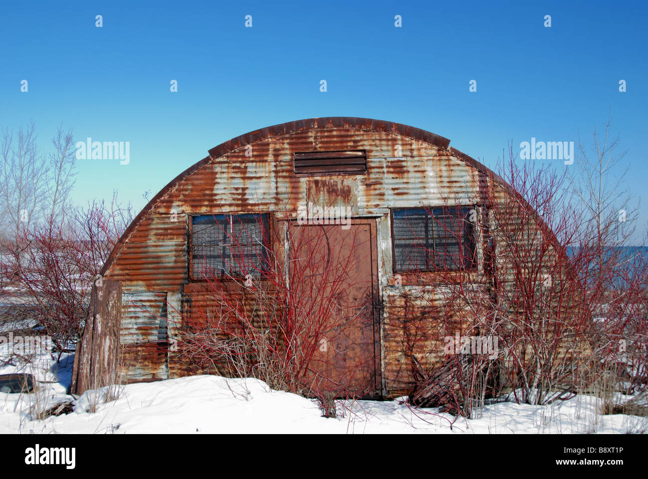 Un vecchio metallo deserte e stagno quonset hut circondato da erbacce ed arbusti sul Leslie spit in Toronto Foto Stock
