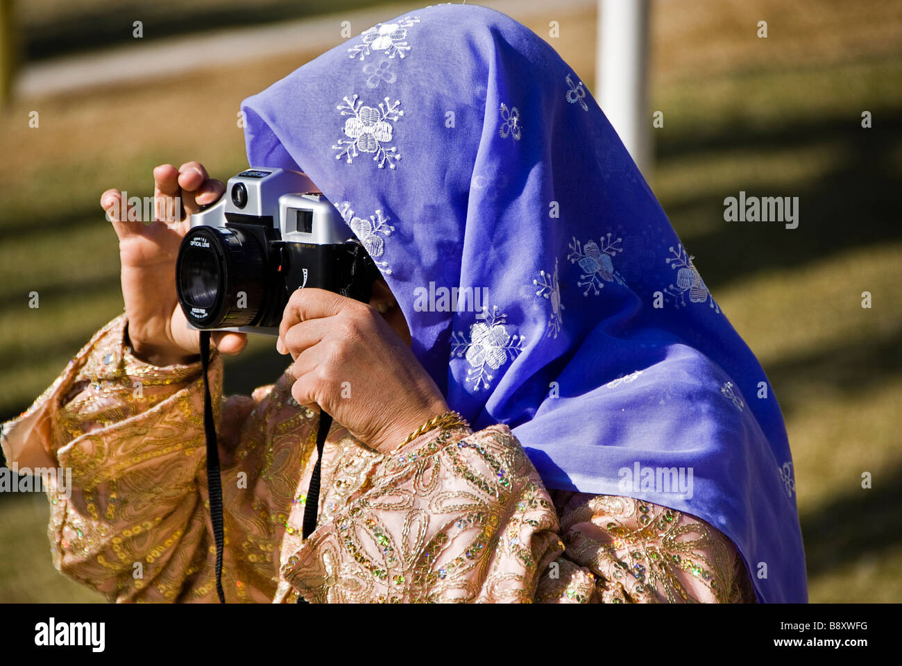 Donna con abiti tradizionali di scattare una foto con una vecchia macchina fotografica, Sanliurfa, Turchia, Asia Foto Stock