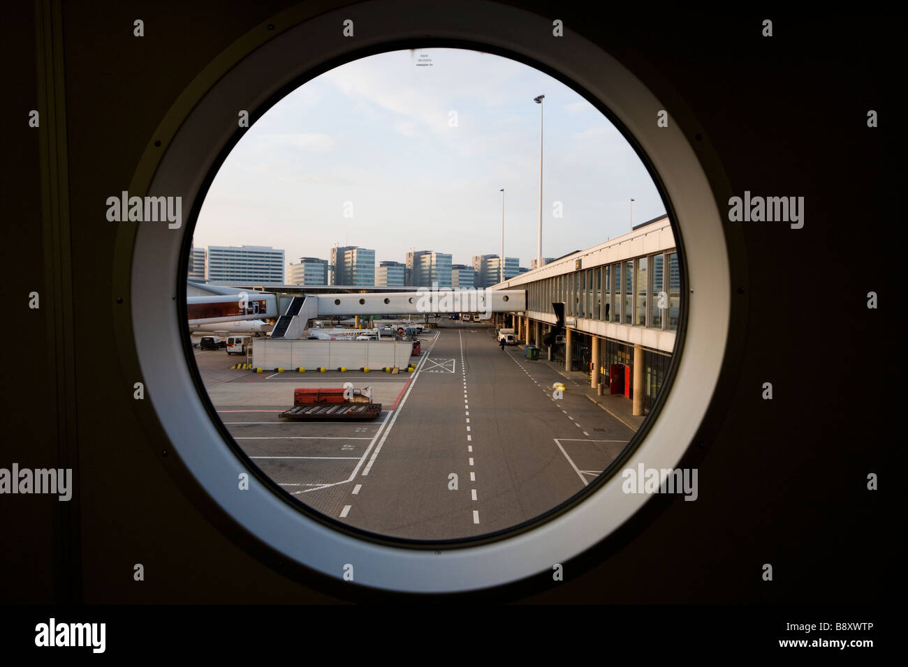 Guardando fuori da una finestra Jetway. Aeroporto Schiphol di Amsterdam. Schiphol WTC in background. Foto Stock