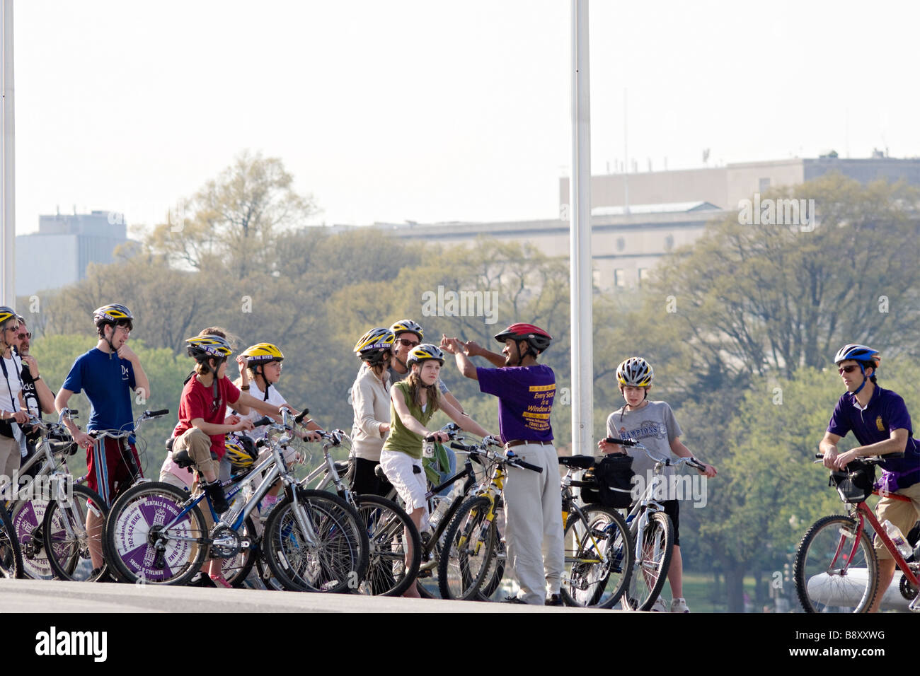 I turisti in bicicletta touring i monumenti di Washington DC con moto i siti. Sotto il Monumento di Washington. Foto Stock