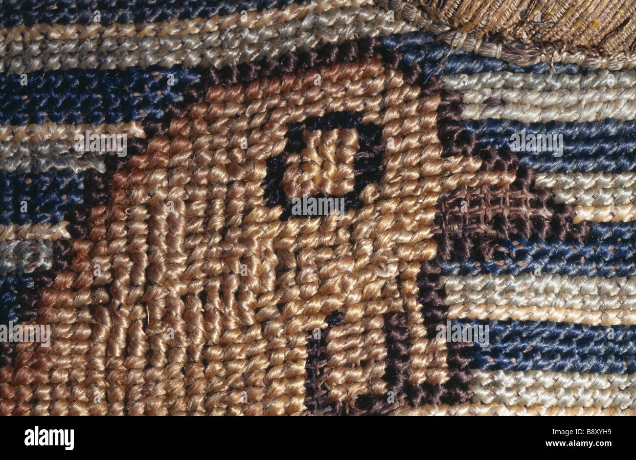 La testa di un uccello contro un bianco blu sullo sfondo a strisce come parte di un motivo da Marian cucito a Oxburgh Hall Foto Stock