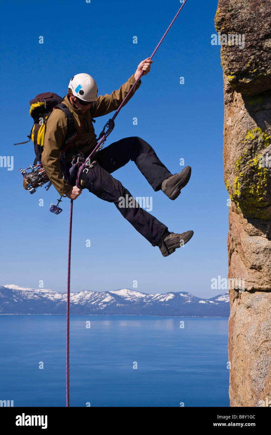 L'uomo rappelling fuori da una scogliera, Lake Tahoe, Nevada, STATI UNITI D'AMERICA Foto Stock