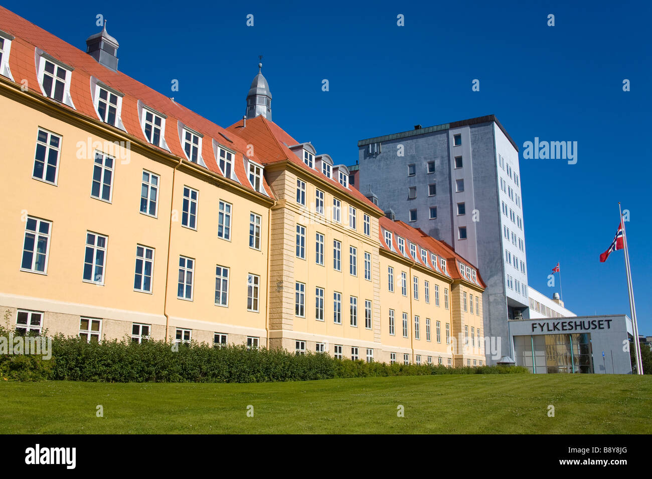 Bandiera norvegese svolazzanti nella parte anteriore di un County Hall, Troms County Hall, Tromso, Toms County, Nord-Norge, Norvegia Foto Stock