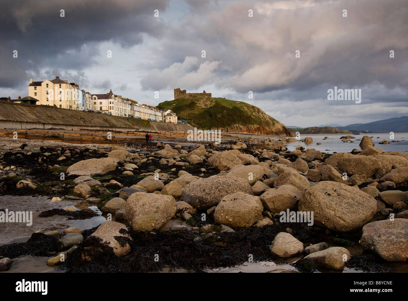 La spiaggia a Criccieth con il castello e le case in background, Gwynedd, Galles. Regno Unito Foto Stock