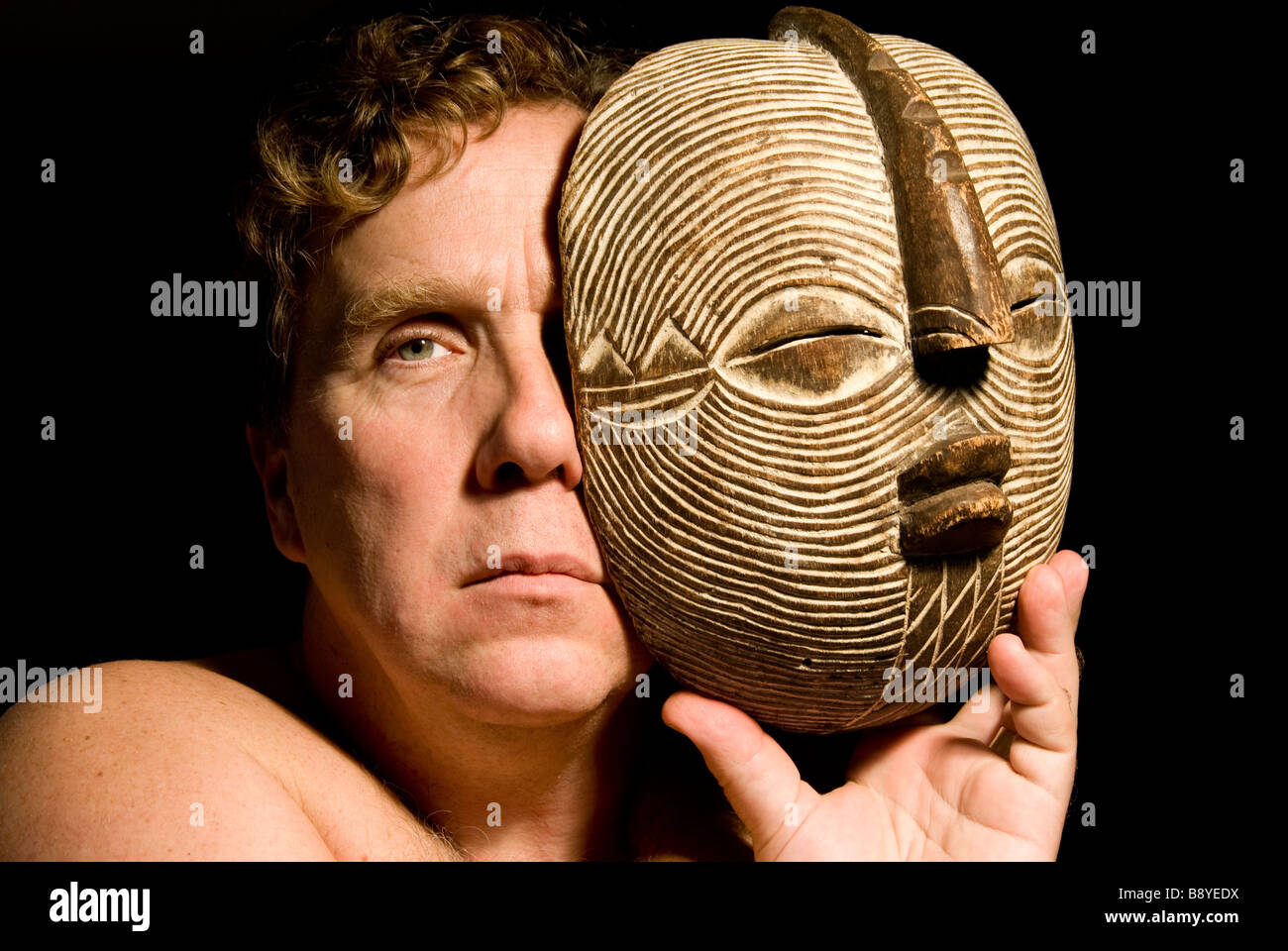 Uomo con una maschera africana Foto Stock