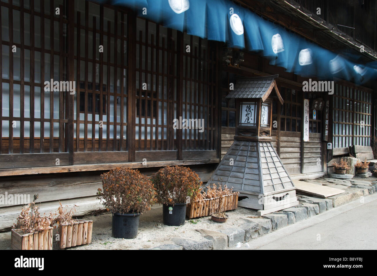 Tende Noren soffiare il vento al di fuori di un edificio tradizionale attualmente un Soba noodle bar in Kiso città di Narai Foto Stock