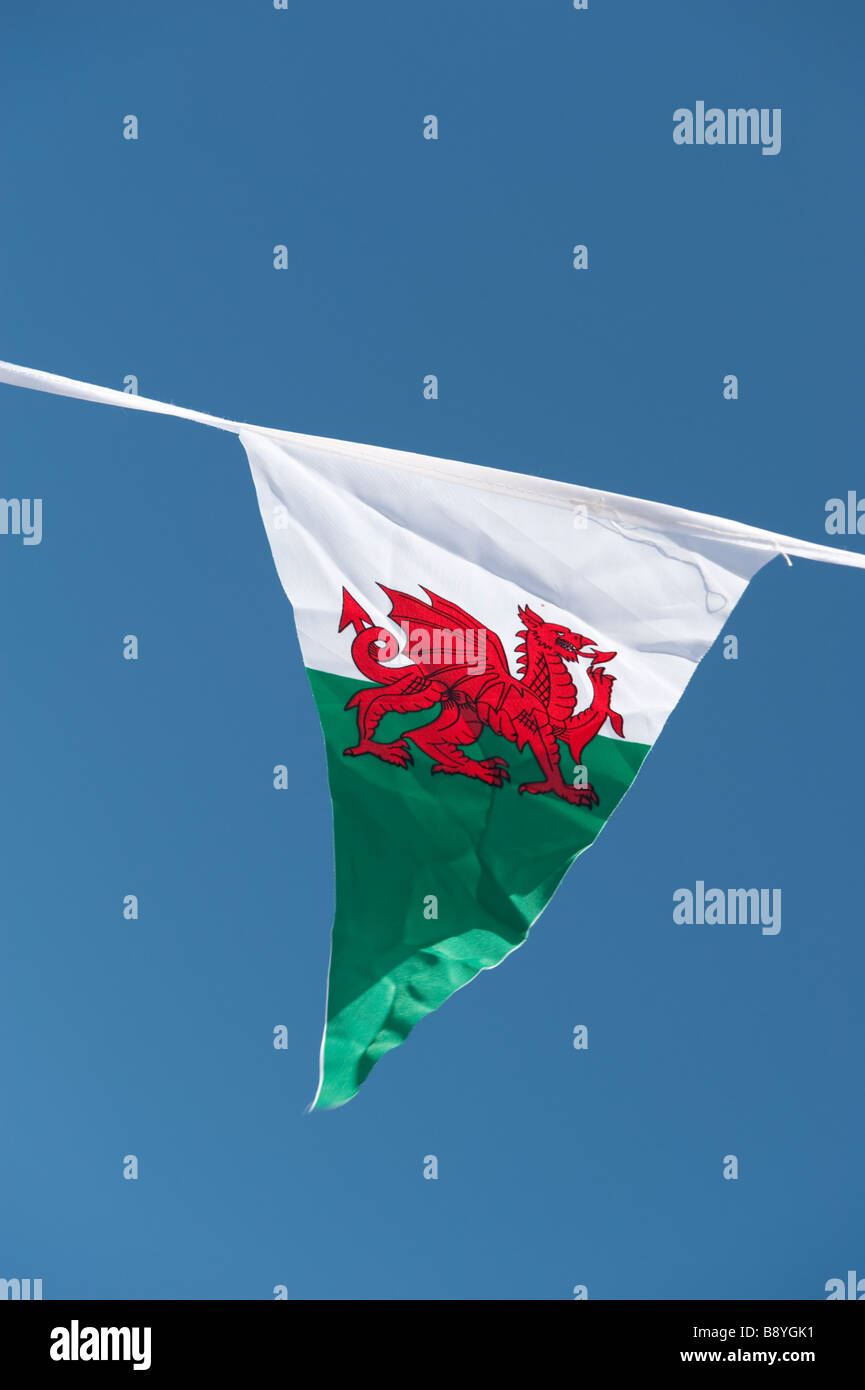 Una forma triangolare Welsh pennant drago rosso emblema nazionale del Galles in volo in un cielo azzurro sul giorno di San Davide , Wales UK Foto Stock