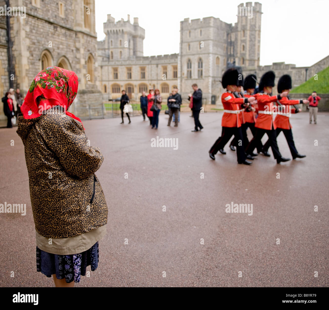 La donna in sciarpa rossa orologi cambio della guardia al Castello di Windsor, Windsor, Inghilterra Foto Stock