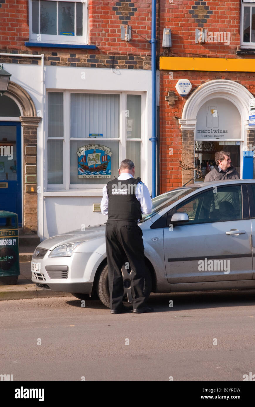 Una comunità di polizia support officer cso di emettere un biglietto di parcheggio su un illegalmente auto parcheggiate nel Regno Unito Foto Stock