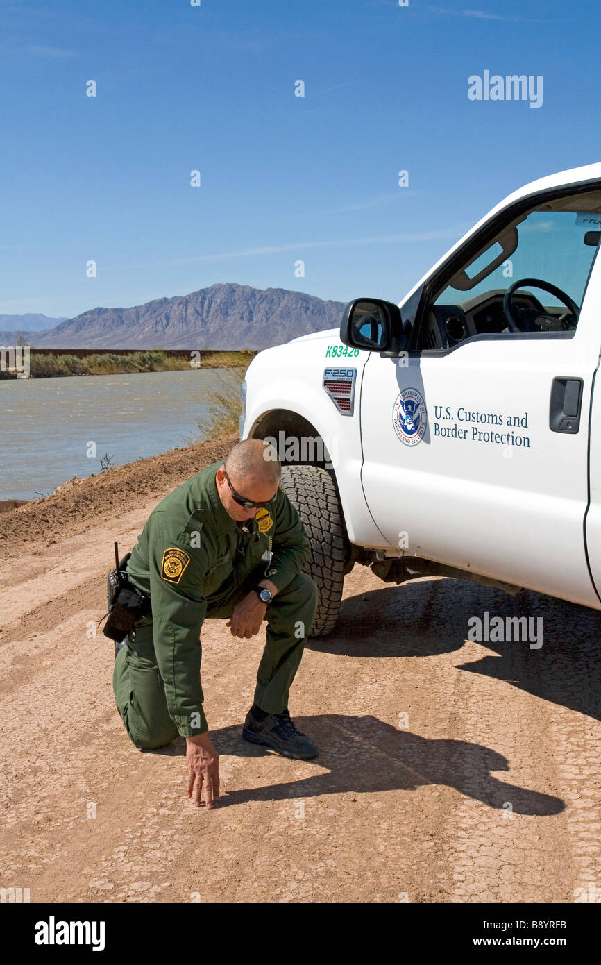 U S Pattuglia di Confine agent verifica per impronte in U S Messico confine lungo tutto il canale americano vicino Calexico California Foto Stock
