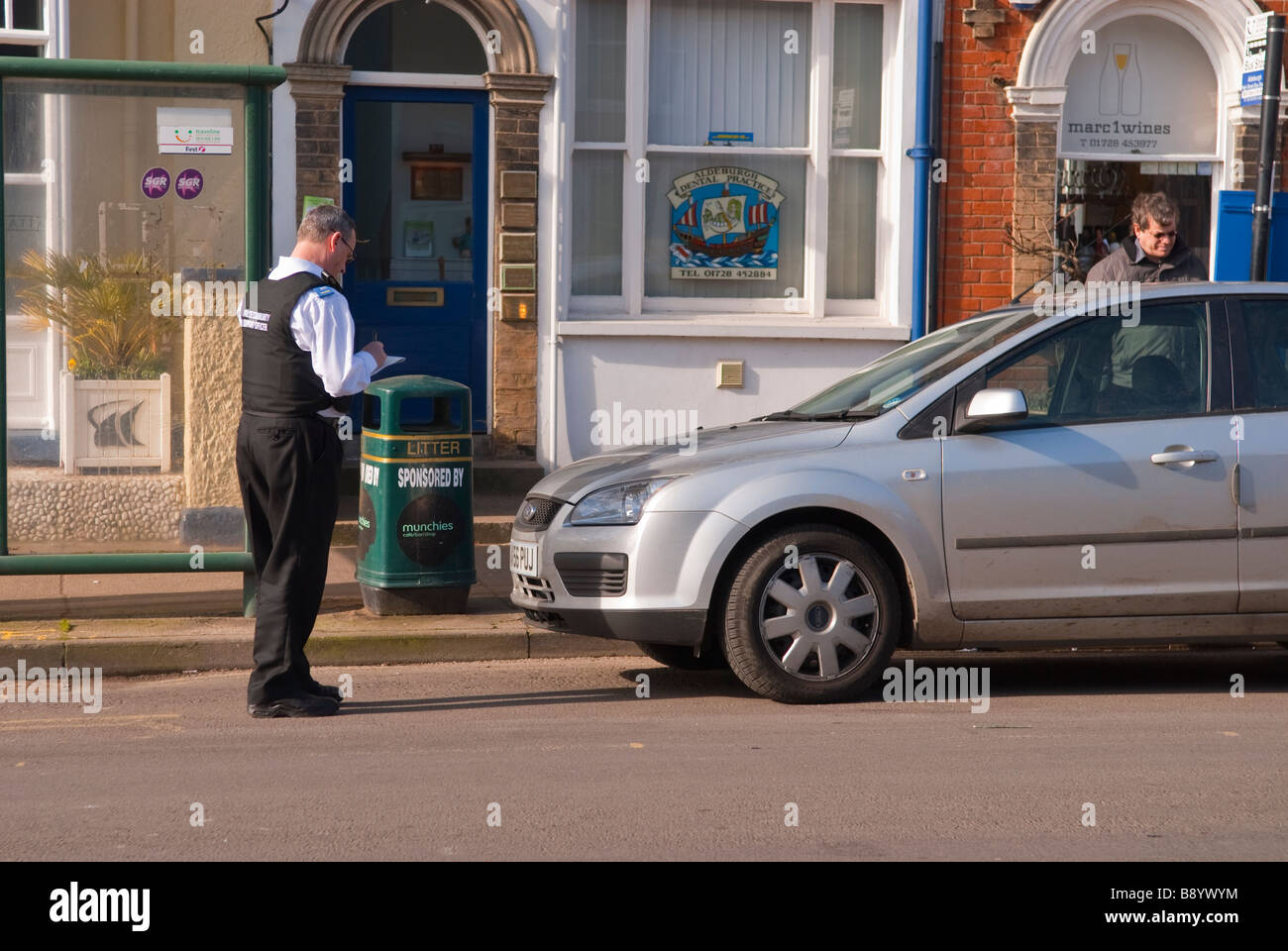 Una comunità di polizia support officer cso di emettere un biglietto di parcheggio su un illegalmente auto parcheggiate nel Regno Unito Foto Stock
