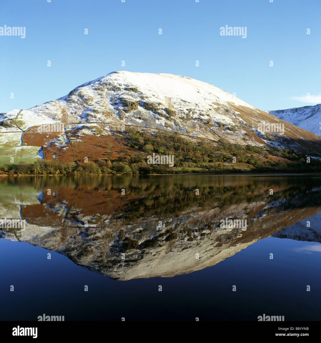 Vista su fratelli acqua della coperta di neve Hartsop Dodd collina perfettamente riflessa nell'acqua ancora Foto Stock