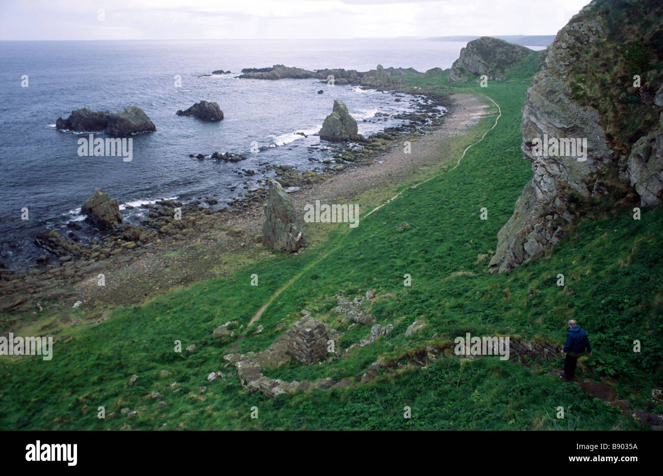 Uomo che scende i Giants Steps su un percorso a piedi vicino a Cullen sulla costa Moray Firth a Moray Nord Est Scozia Foto Stock